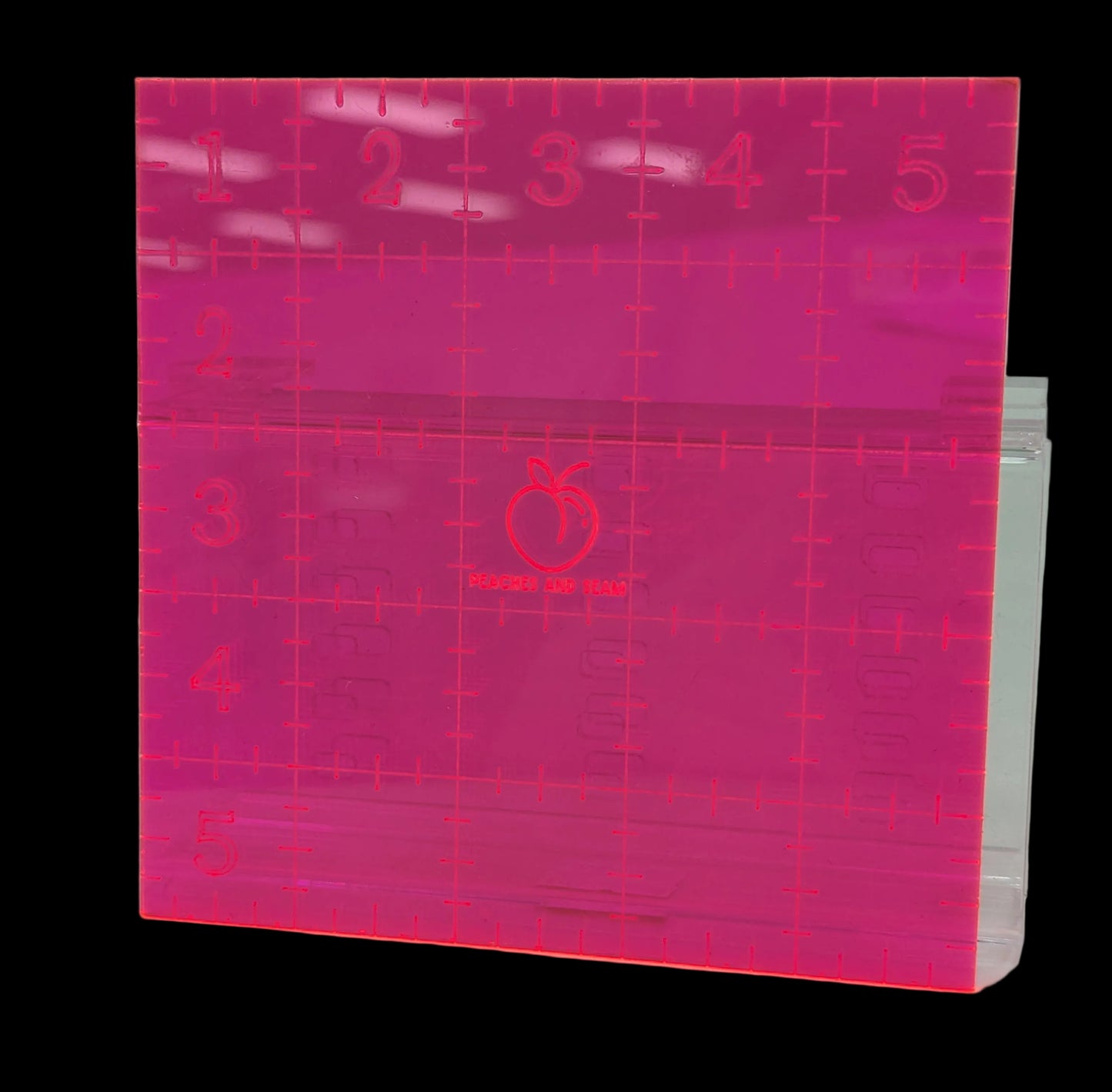 Pink acrylic 5" square ruler with grid lines and measurements on a white background