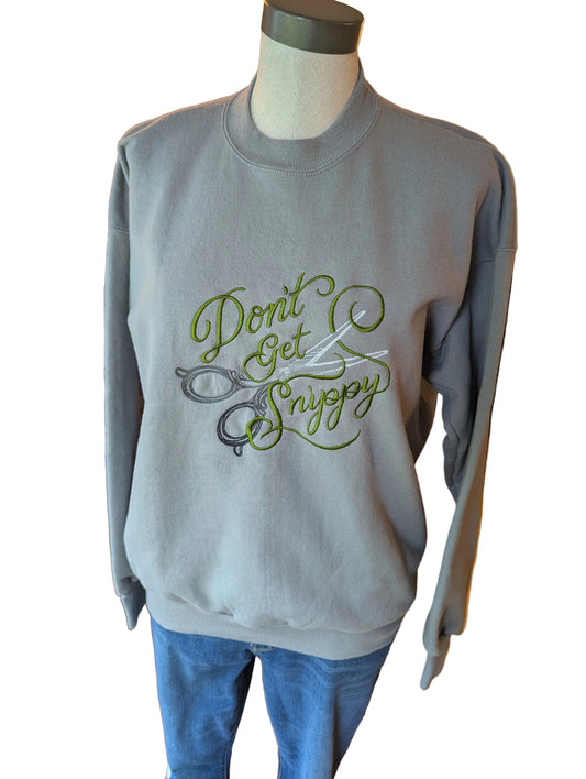 Gray sweatshirt with 'Don't Get Snippy' text and scissors graphic on a mannequin