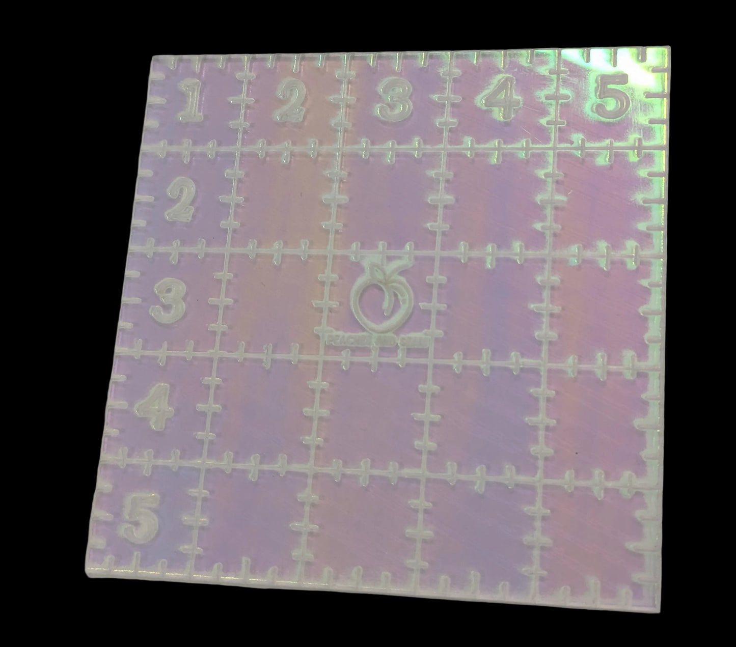 iridescent 5" ruler with numbers and symbols on a gray background