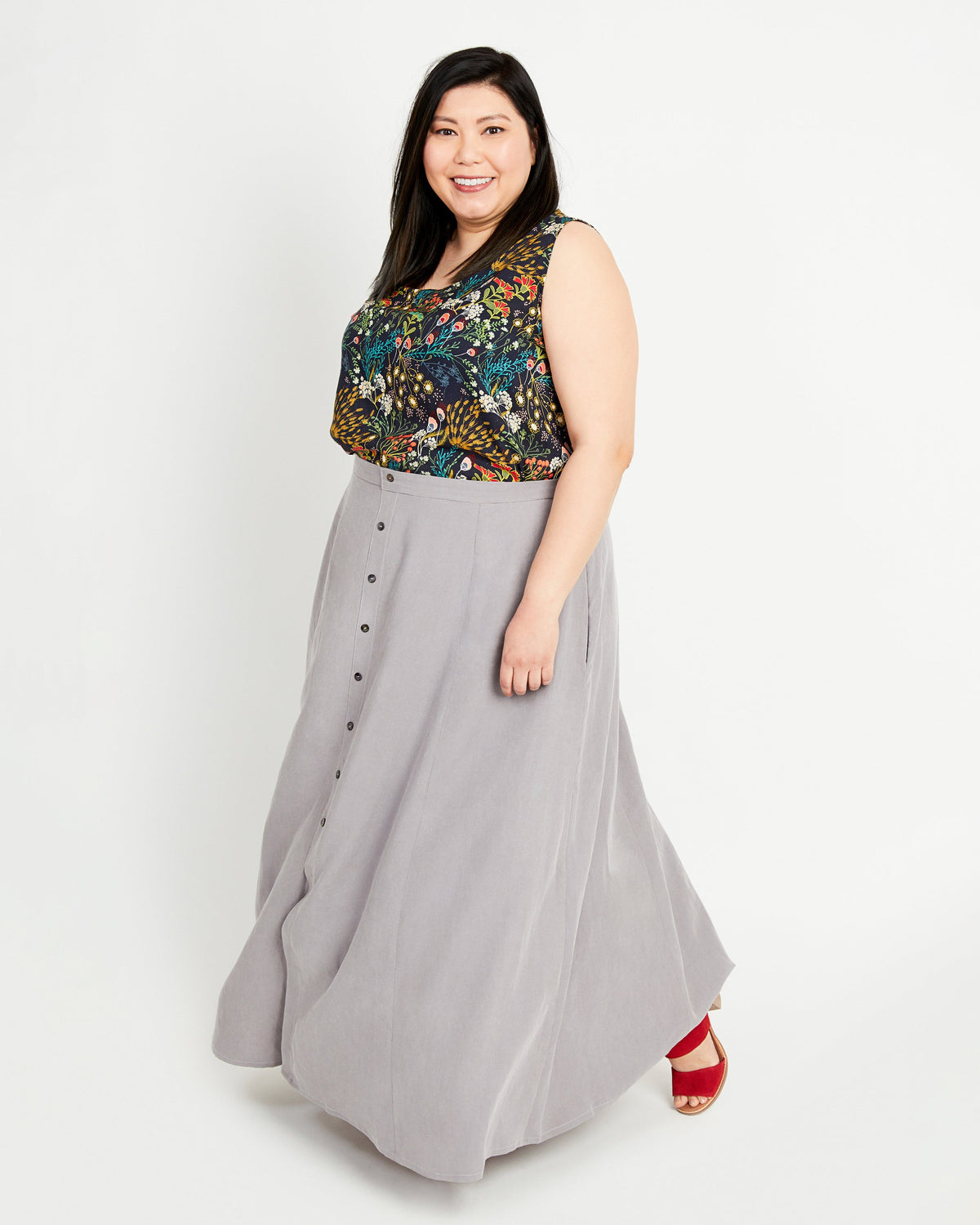 Woman wearing a floral top and gray skirt on a white background. This is the Holyoke Maxi Dress & Skirt sewing pattern from Cashmerette.